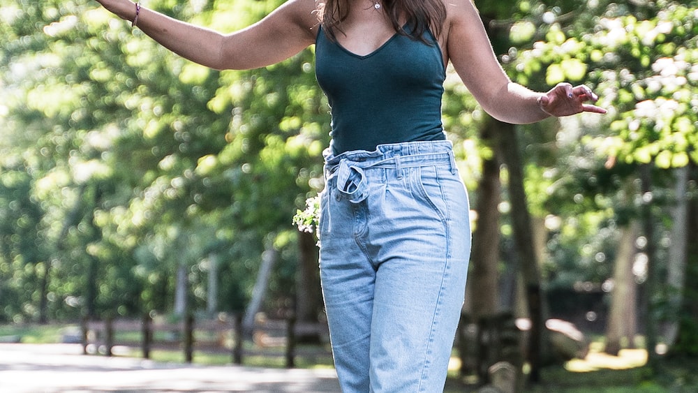 Achieving Balance: Girl Balancing on Fence Among Trees