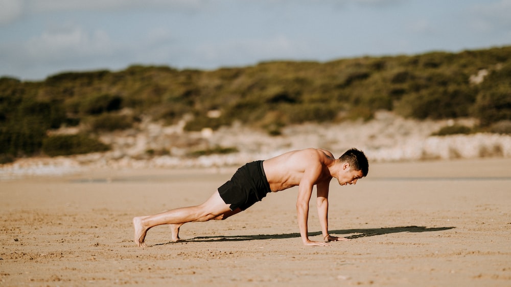 Active Listening: Man Doing Push-Ups on Sand
