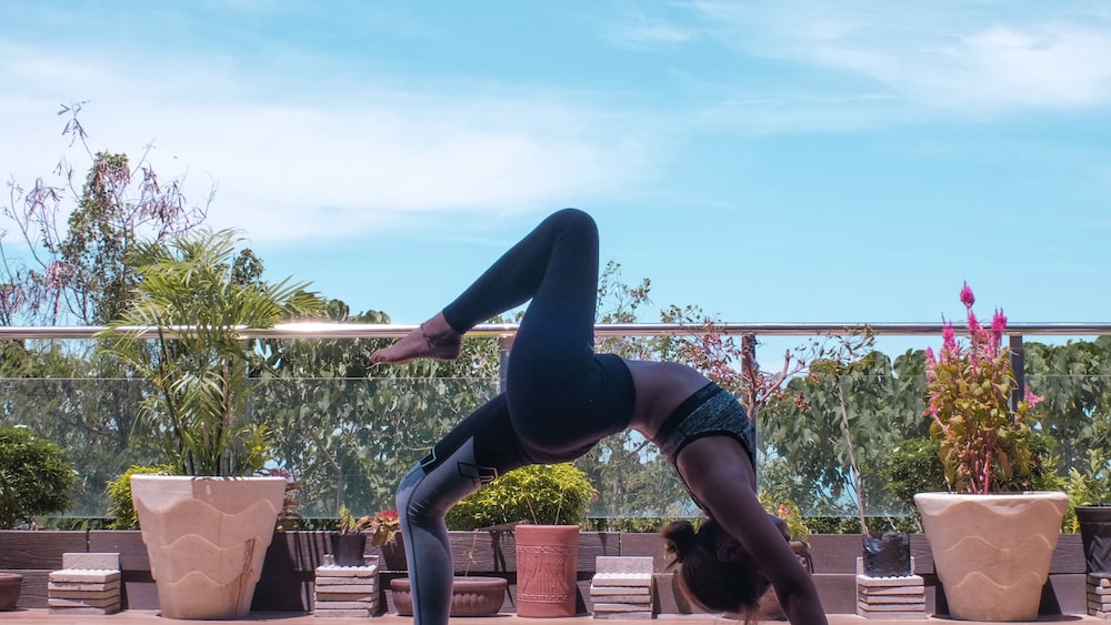 Black-clad woman performing yoga wheel pose