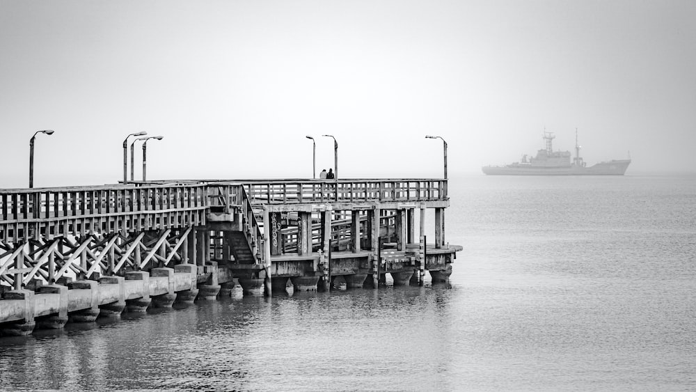 Captivating Black and White Pier with a Boat