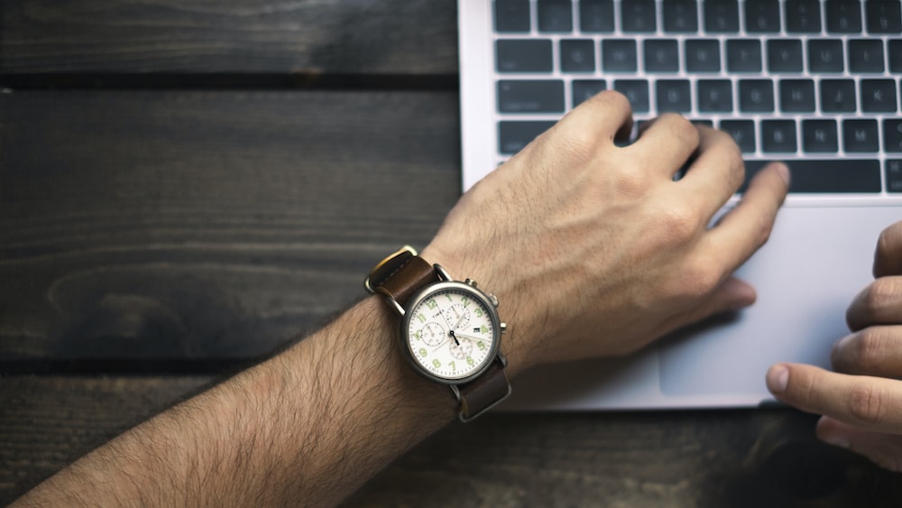 Efficient Time Management: Man Typing with Brown and White Watch