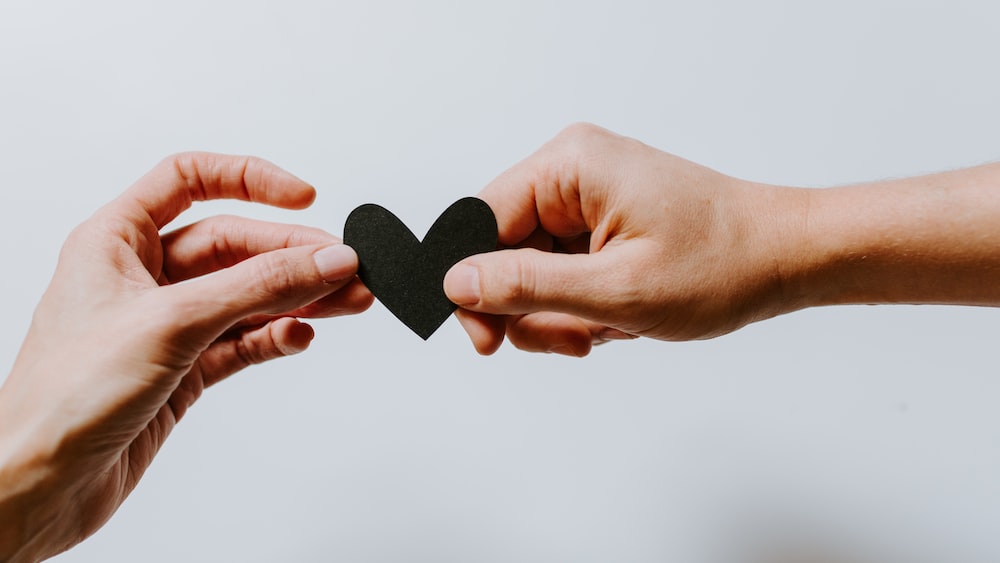 Enhancing Relationships: Two People Holding a Papercut Heart