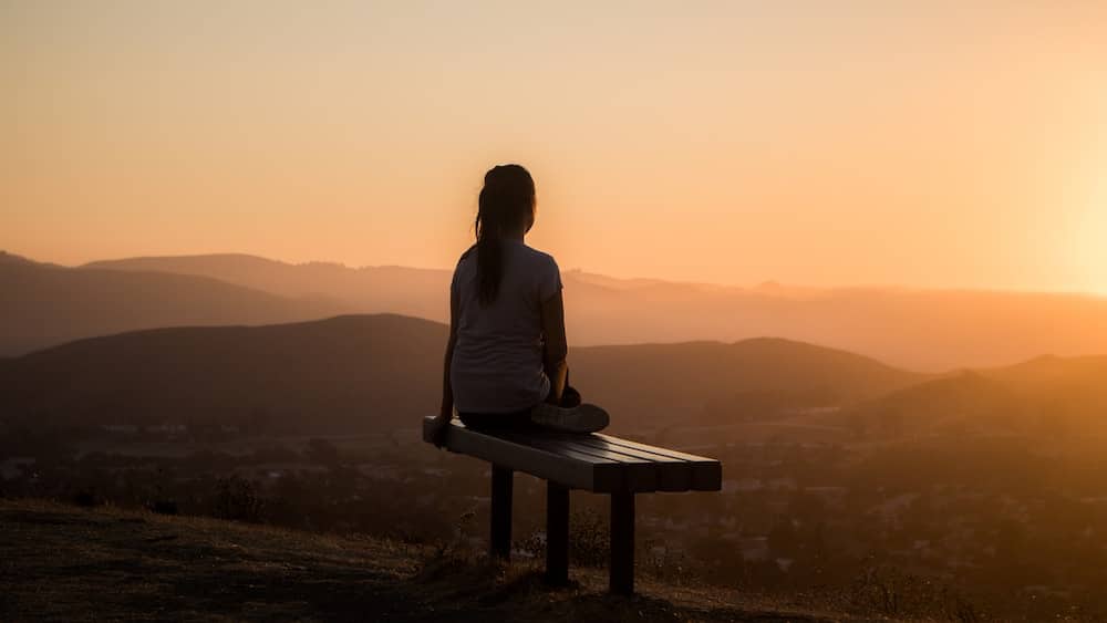 Finding Inner Peace Through Meditation: Woman Meditating on a Mountain Bench