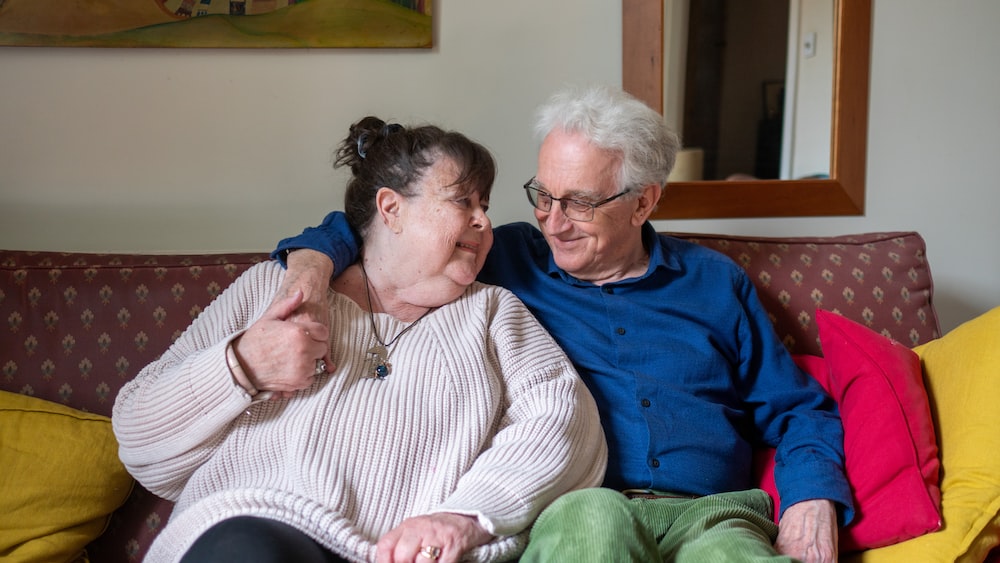 Grateful Smiling Elderly Couple on Sofa