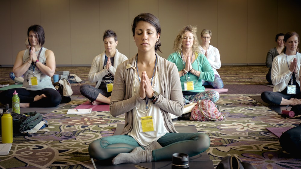 Group of people doing mindfulness yoga practice at the Midwest Yoga and Oneness Festival.