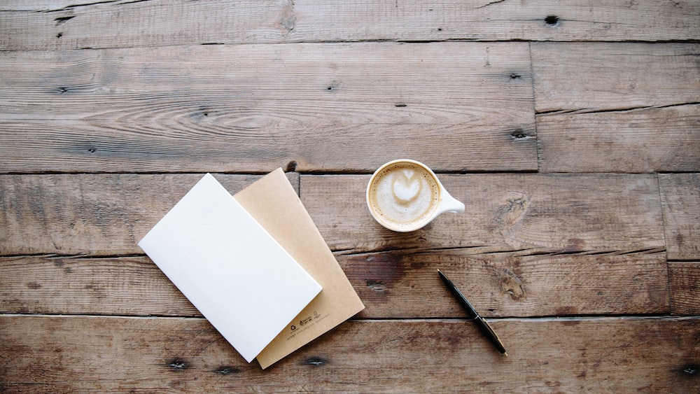 Journal Selection Essentials: Coffee, Notebooks, and a Black Twist Pen