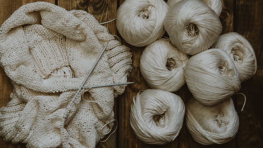Knitting Essentials: White Yarn on Brown Wooden Table