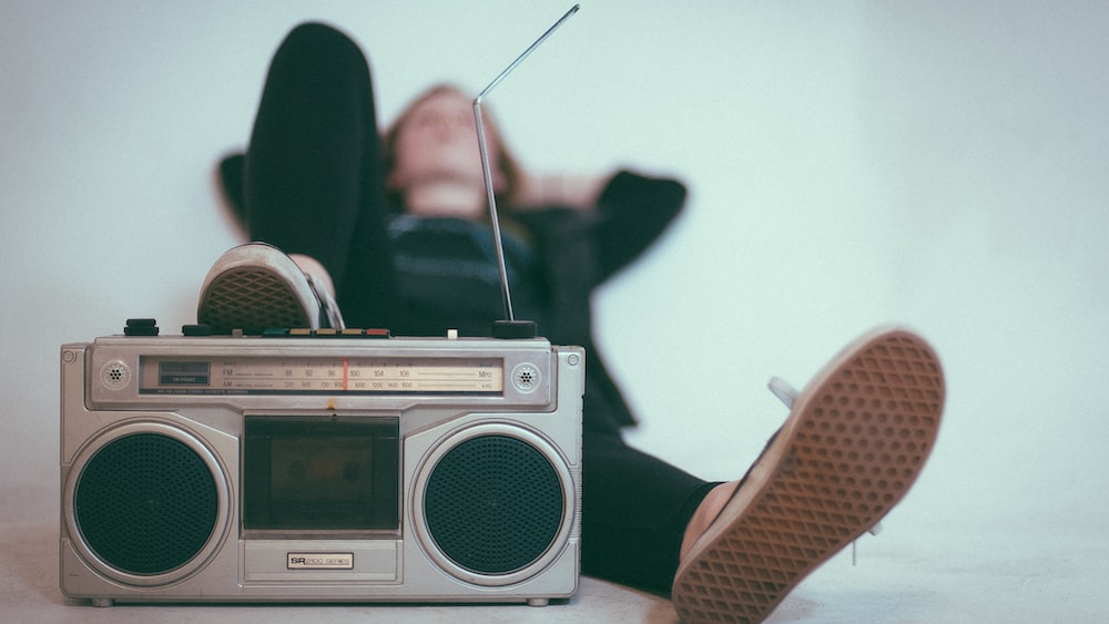 Listening with Intent: A Woman Relaxing near a Gray Radio