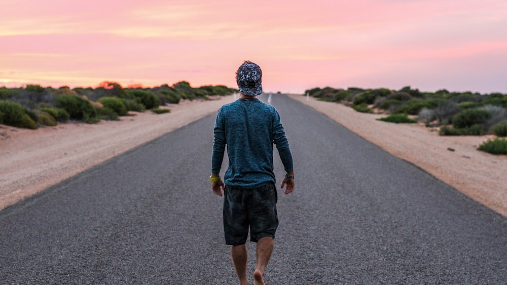 Man Practicing Mindful Walking on Gray Concrete Road