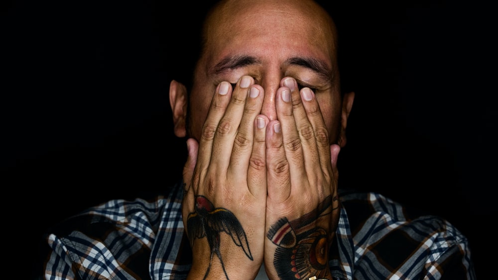 Man demonstrating emotional maturity by covering his face