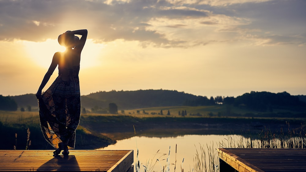 Mindful Moment: Woman in Silhouette at Golden Hour on Wooden Dock