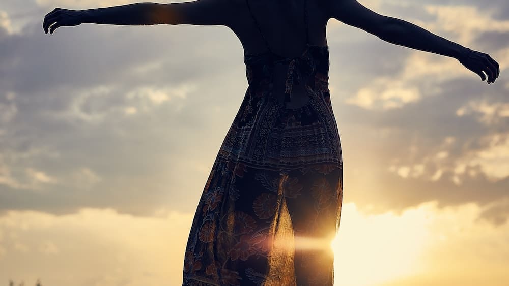 Mindful Release: Silhouette of Woman Embracing Freedom at Sunset