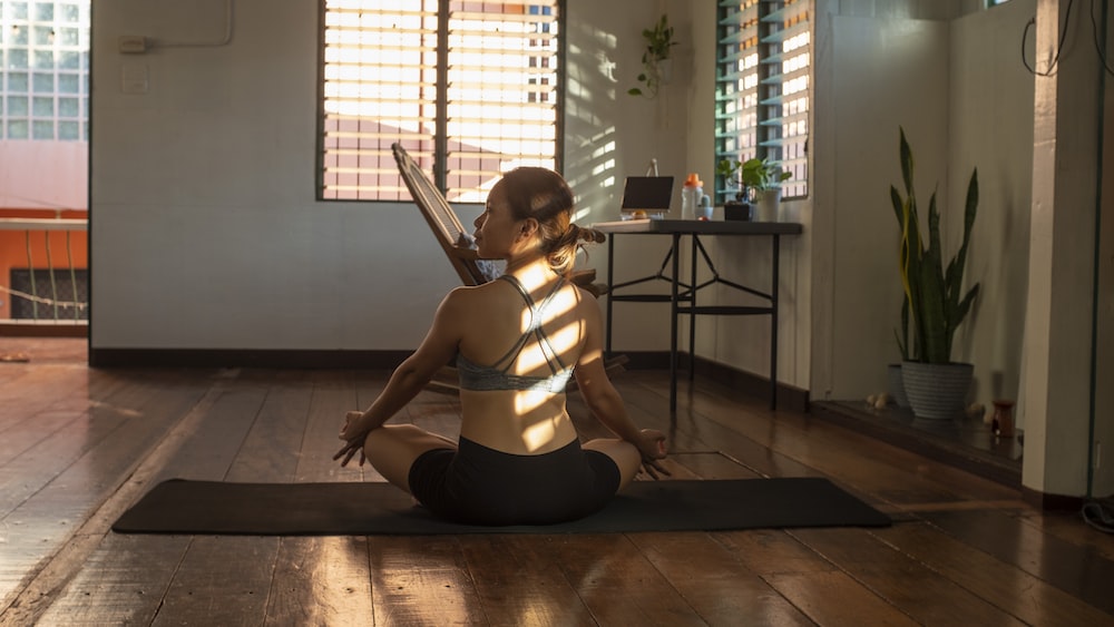 Mindful Yoga Pose: Woman in White Tank Top Practicing Mindfulness on Wooden Floor