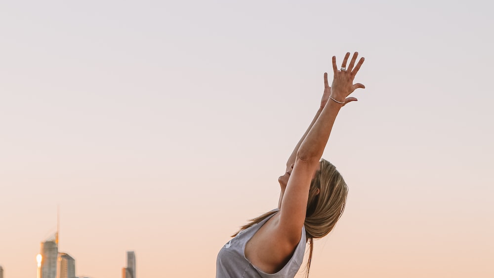 Mindful Yoga at Sunset: Woman in White Shirt Raising Hands on Mermaid Beach, Gold Coast, Australia
