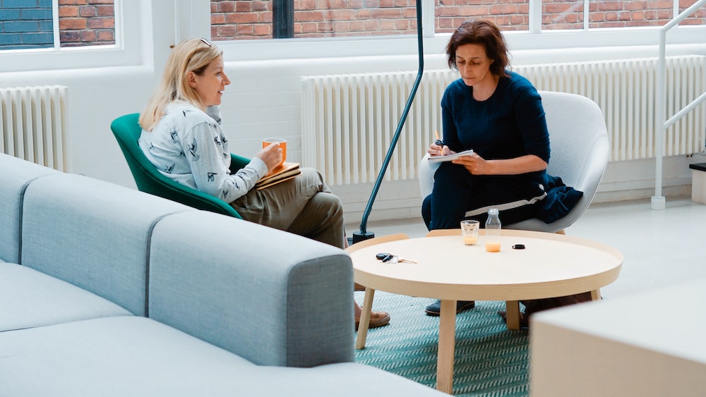 Mindfulness Coaching Session: Two Women Discussing on Sofa