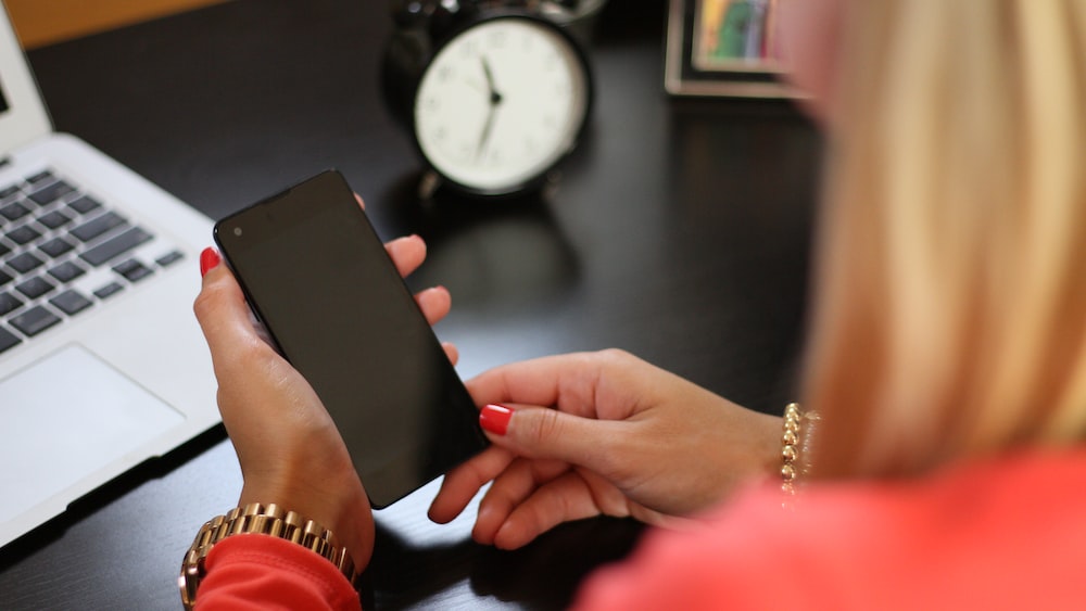 Minimizing Digital Interruptions: Woman at Desk with Smartphone