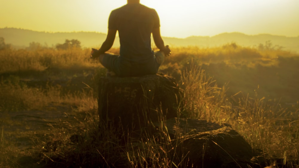 Morning Meditation: A Man Sitting on Brown Grass.