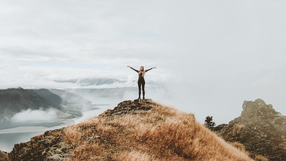 Motivation: Woman Standing on Top of Hill