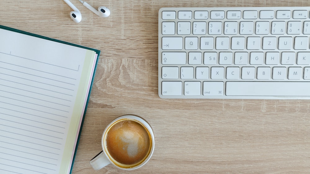 Organized workspace with coffee and Apple EarPods