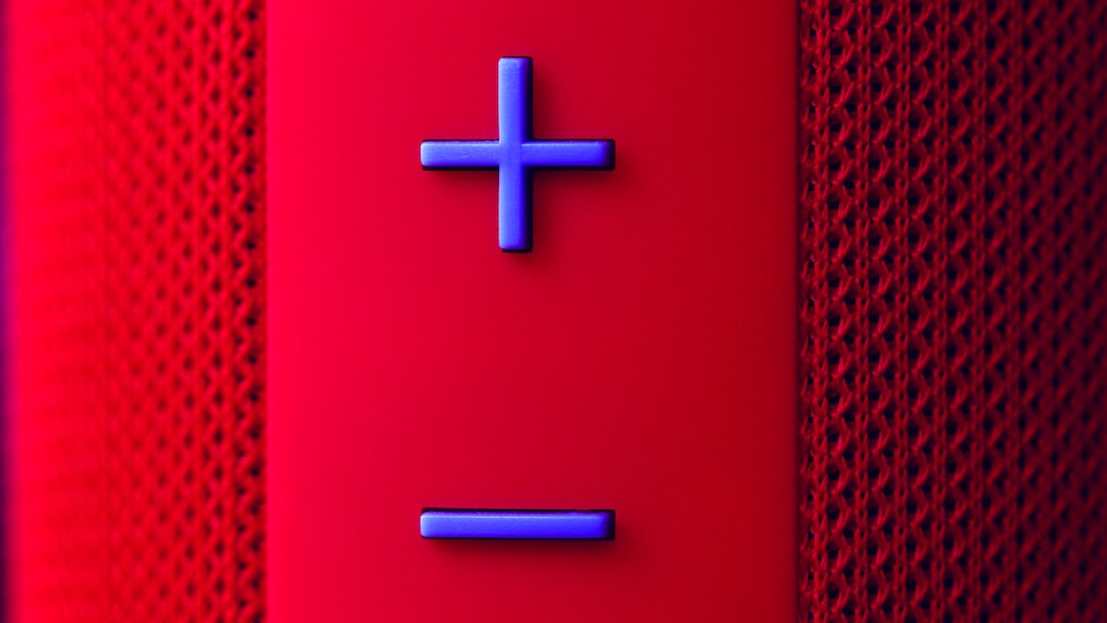 Pause: A Close-up of a Red Bluetooth Speaker Button