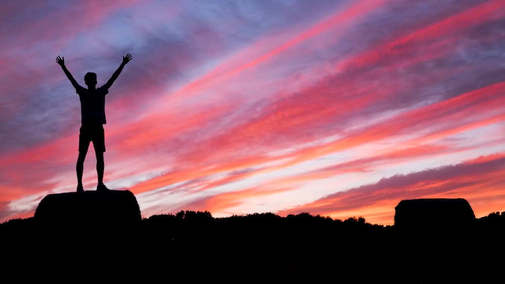 Reaching Success: A Silhouetted Figure Standing on High Ground