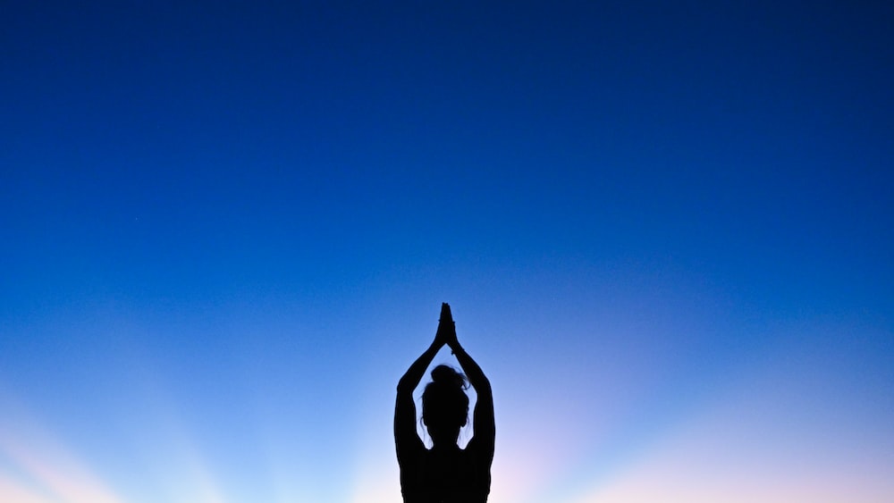 Silhouette of a Woman Practicing Mindful Yoga at Sunset