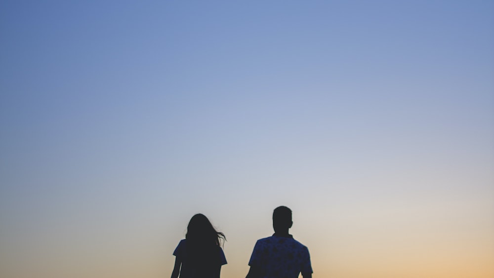 Silhouette of a couple holding hands on the beach