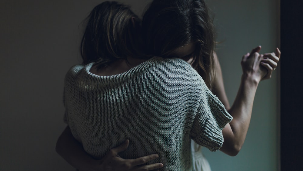 Sisters embracing in an emotional goodbye