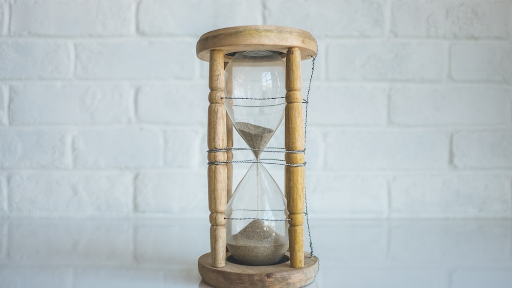 Time Management Symbol: Clear Hour Glass with Brown Frame