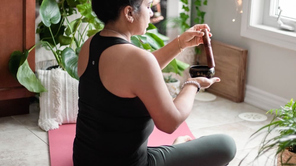 Woman meditating on pink yoga mat